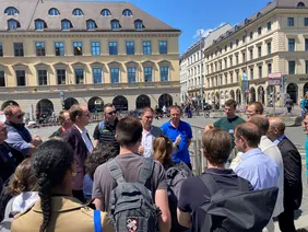 Bei hochsommerlichen Temperaturen erläuterte Dr. Patrick Krystallas kurz vor dem Einstieg in die Anlage am Odeonsplatz das konkrete Anlagenkonzept vor Ort.