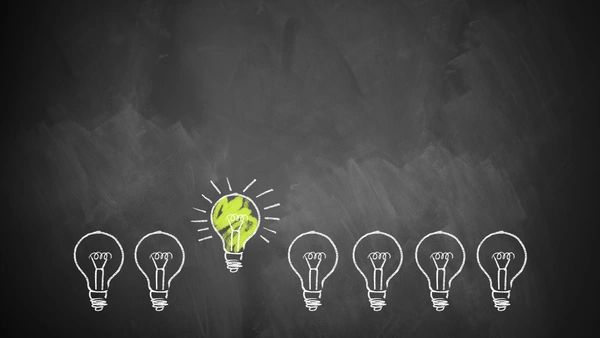 Representations of light bulbs in a row from which a shining light bulb is highlighted.