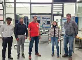 Mühenad Bilal (Mitte) mit Kolleginnen und Kollegen: An der THI entstand im Rahmen seiner Dissertation eine KI-Lösung, die industrielle Werkzeugprüfung neu denkt (Foto: Mühenad Bilal privat).
