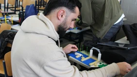 Eine männliche Person arbeitet mit Legosteinen