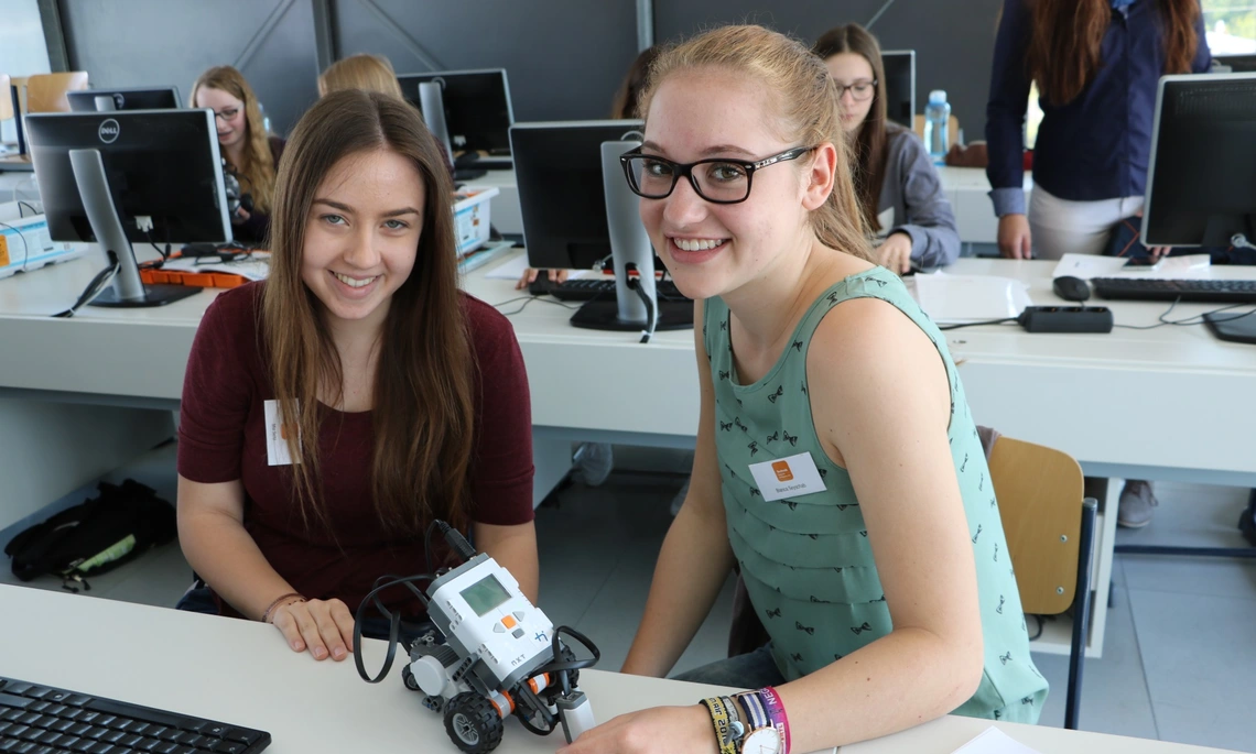 Zwei Mädchen mit einem kleinen Roboter