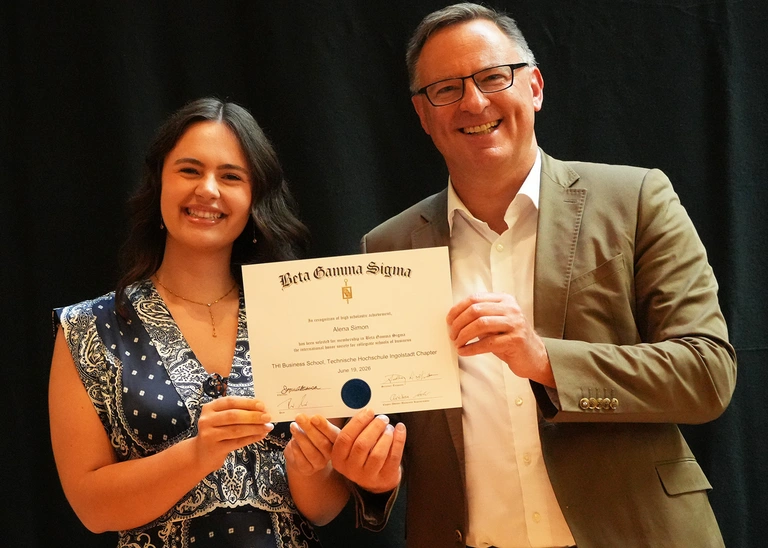 A woman and a man present a certificate.