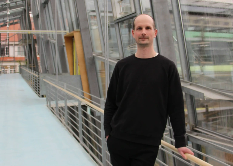 A man dressed in black in a modern glass building